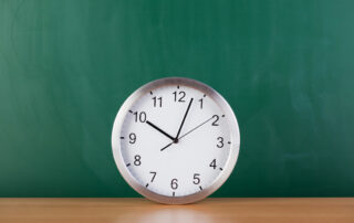 act timing tips, clock against a chalkboard for exam timing.